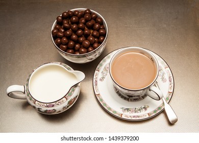 Cup Of Tea With Jar Of Milk And Sweets On A Metallic Table From Above