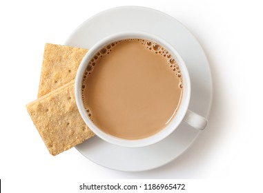 A Cup Of Tea With Milk And Two Square Shortbread Biscuits Isolated On White From Above. White Ceramic Cup And Saucer.