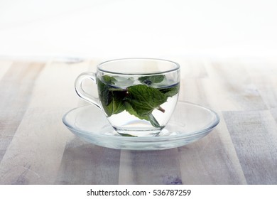 Cup of tea and mint leaf on a wooden background - hot water in a tearoom place