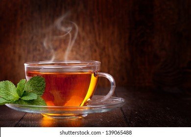 Cup of tea and mint on a wooden background