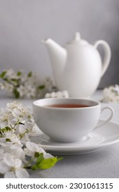 A cup of tea on the table with spring cherry blossoming branches. Spring and cozy concept.