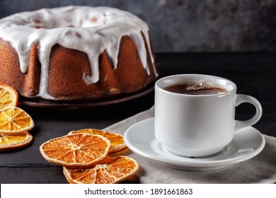 Cup of tea with oranges and a piece of homemade muffin