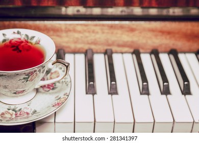 A cup of tea and a piano in a vintage toning - Powered by Shutterstock