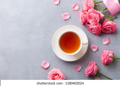 Cup of tea with pink rose. Top view. Copy space. Grey stone background. - Powered by Shutterstock