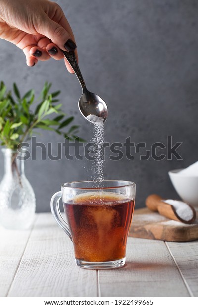 In a cup of tea, pour a sugar substitute from\
a teaspoon. Stevia,\
erythritol.