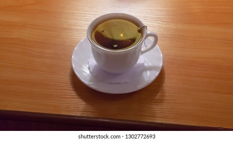 Cup of tea with tea strainer on the table