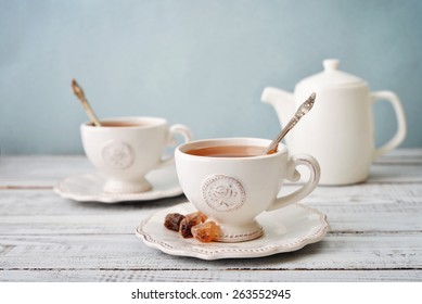 Cup Of Tea And Sugar With Teapot Over Blue Background