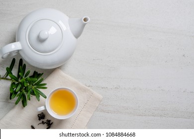 Cup With Tea And Teapot On White Stone Table.Top View With Copy Space.