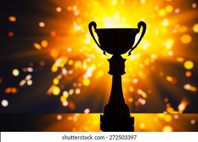 Cup Trophy Silhouette Against Shiny Sparks Background