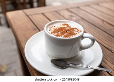 Cup of turkish traditional winter beverage Salep (Sahlep or sahlab) served with cinnamon on top in Istanbul cafe