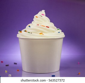 Cup Of Vanilla Frozen Yogurt With Sprinkles Against A Purple Background