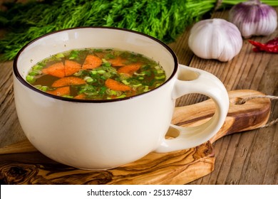 cup with vegetable soup on a rustic wooden background