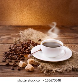 Cup of warm coffee, coffee beans and sugar cubes on  wooden surface. Free space for your text. - Powered by Shutterstock