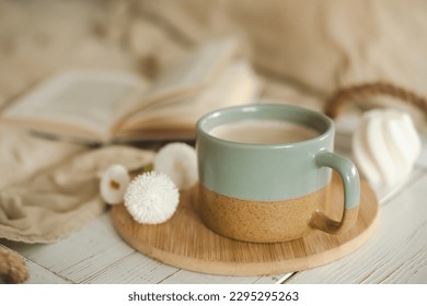 A cup of warm, warming aromatic tea, coffee, flowers nearby
