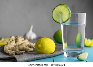 Cup Of Water With Lemon, Garlic And Ginger On Blue Wooden Table. Prevention Of Colds. Increased Immunity