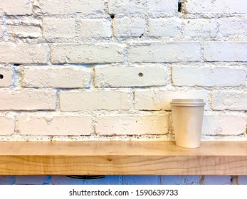 Cup and White Brick Wall