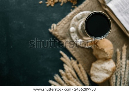 Cup with wine, bread and open Bible, Christian communion.