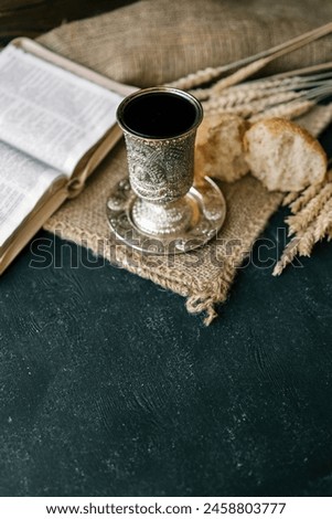Cup with wine, bread and open Bible, Christian communion.