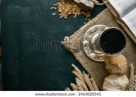 Cup with wine, bread and open Bible, Christian communion.