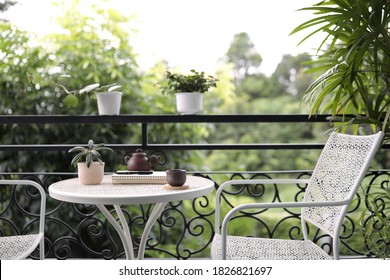 Cup Wit Plants In Pots With Notebook On White Metal Table At Balcony Outdoor