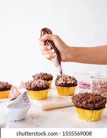 Cupcake Decorating With Hands And Icing Bag