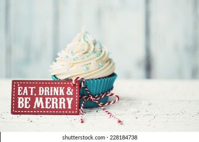 Cupcake with "Eat, drink and be merry" sign