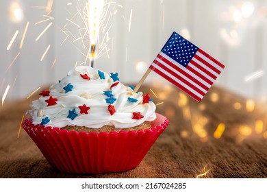 a cupcake with a flag and sparkler - Powered by Shutterstock