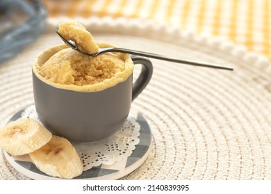 cupcake in a mug with banana pieces. Banana cupcake on a light background. vanilla biscuit in a mug. The concept of a dessert in the microwave. bananas cake. High quality photo