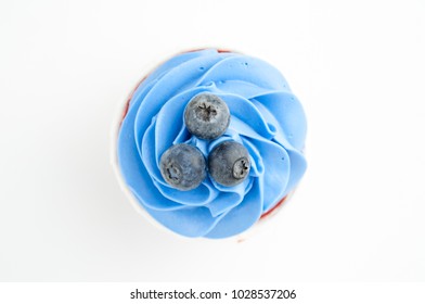 Cupcake Red Velvet With Blue Whipped Cream Decorated With Blueberry On White Background. Picture For A Menu Or A Confectionery Catalog. Top View.