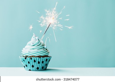 Cupcake With Sparkler Against Blue