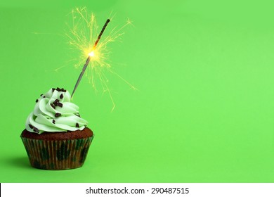 cupcake with sparkler against a green background - Powered by Shutterstock