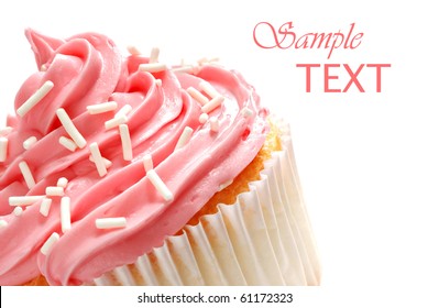 Cupcake with swirls of creamy strawberry frosting on white background with copy space.  Macro with shallow dof.