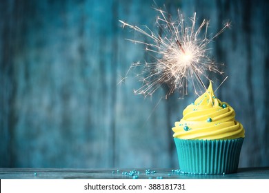 Cupcake with yellow buttercream and a sparkler