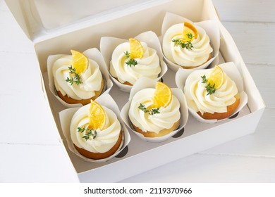 Cupcakes  decorated with dried lemon and thyme  in delivery paper box. Sweet food delivery. Fruits cup cakes, menu design or recipe background