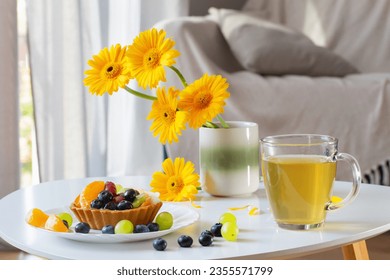 cupcakes with fruits and green tea on white  table at home - Shutterstock ID 2355571799