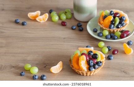 cupcakes with fruits on wooden table on kitchen - Shutterstock ID 2376018961