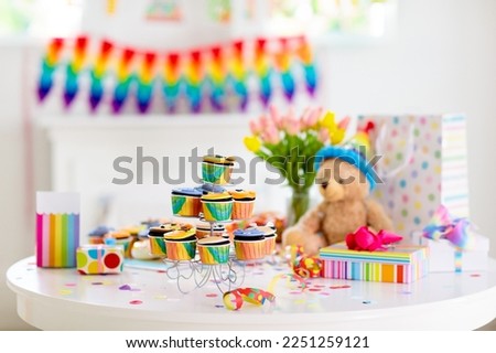 Cupcakes for kids birthday celebration. Jungle animals theme children party. Decorated room for boy or girl kid birthday. Table setting with presents, gift boxes, confetti and sweets. Pastry for child