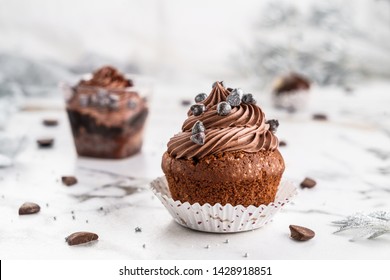 Cupcakes or muffins with chocolate cream and candy on light marble background. Holiday cake celebration, delicious dessert, close up - Powered by Shutterstock