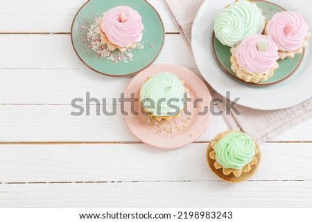 cupcakes on plates on white wooden background