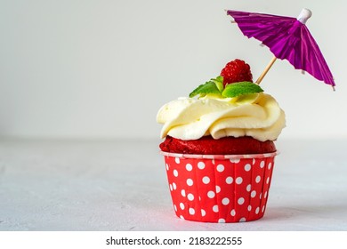 Cupcakes Red Velvet With Pink Cream Decorated With Raspberry And Menthol Stands Under An Umbrella. Copy Space. Delicious Delicacy. Muffin With Cream. Cake.