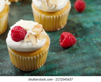 Cupcakes With White Cream, Raspberries And Almonds On A Dark Green Background. Children And Youth Culture, Fast Food, Light Summer Dessert, Birthday, Holiday Treat.