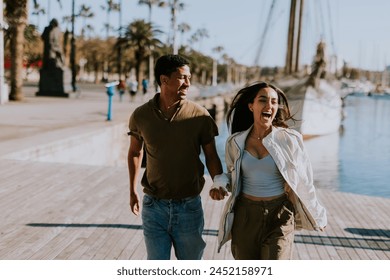 Cuple enjoys a peaceful walk beside moored boats in Barcelona tranquil marina, basking in the soft morning light. - Powered by Shutterstock