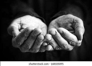 Cupped hands of a man hopefully held up. Cupped hands asking for something.