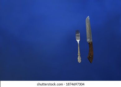 Cupronickel Fork And Knife On A Blue Background.