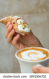 Cups of cappuccino and fresh ricotta cannoli dessert in coffee bar in Sicily, Italy. Cannoli is a traditional sicilian dessert