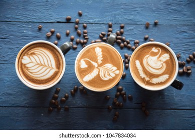 cups of cappuccino with latte art on blue wooden background,top view,flat lay