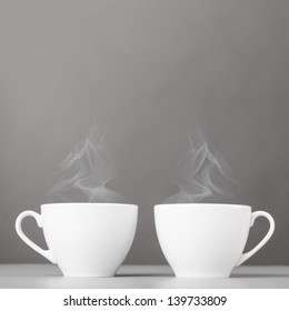 Cups Of Hot Coffee On Gray Background