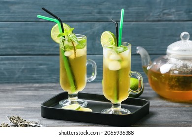 Cups of tasty cold ice tea on table