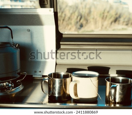 Cups of tea by the window with a view of nature. Tea making in a camper van.            