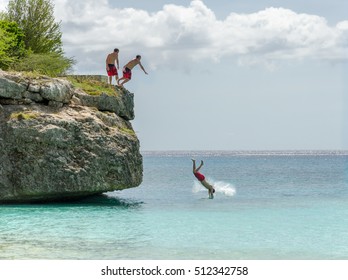 Curacao, Caribbean - october 1, 2012: Tourist jumping from the rock at the Grand Knip Beach in Curacao at the Dutch Antilles, a Caribbean island. Photo 5/5